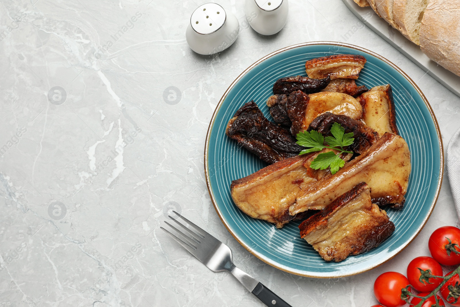 Photo of Tasty fried pork lard with parsley on light table, flat lay. Space for text