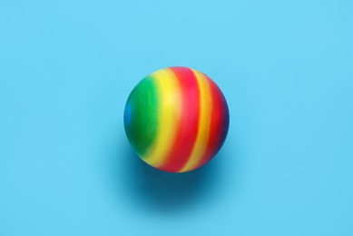 Photo of Bright rubber kids' ball on light blue background, top view