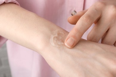 Photo of Woman applying ointment on her hand, closeup