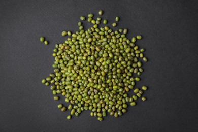 Photo of Pile of green mung beans on black background, top view