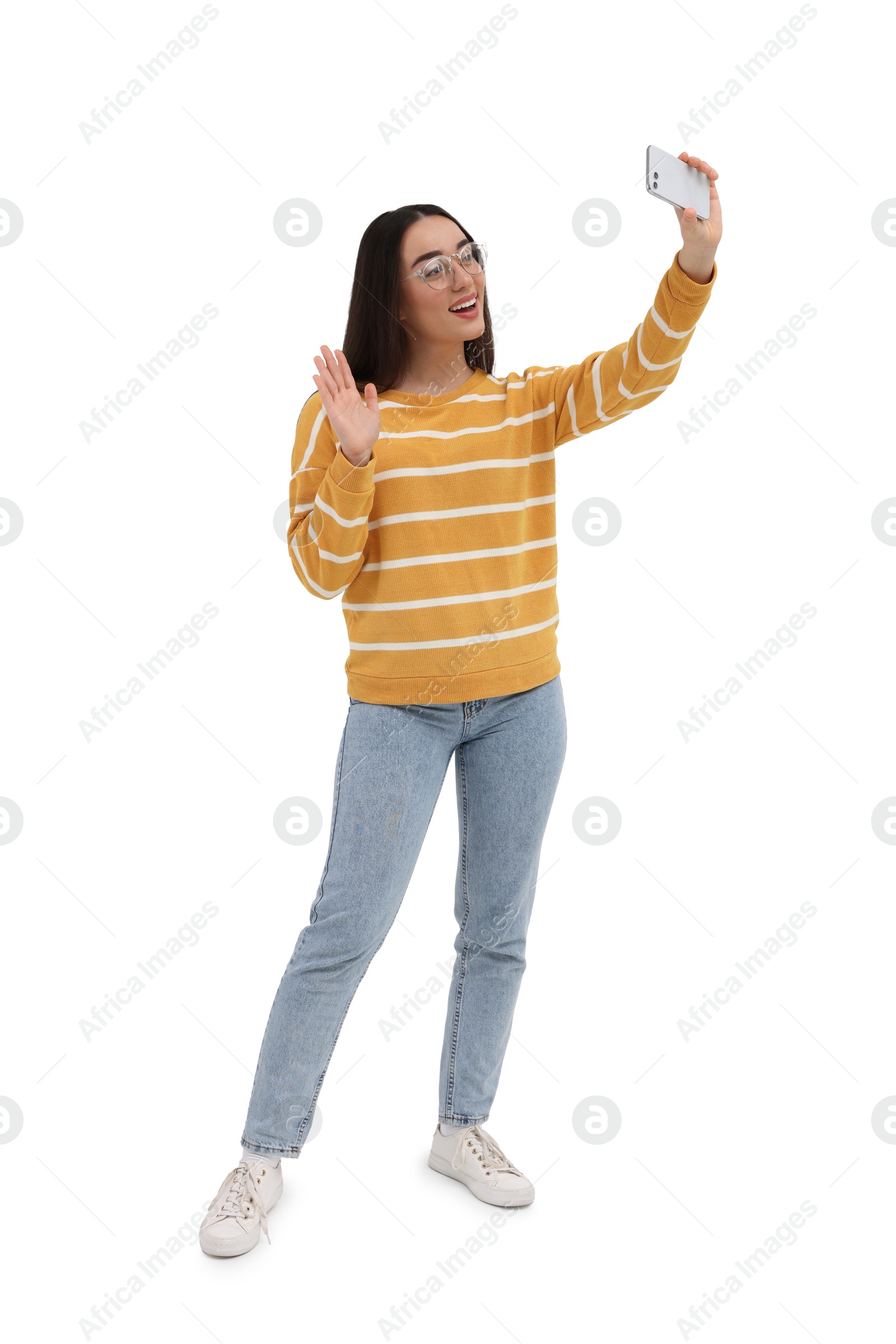 Photo of Smiling young woman taking selfie with smartphone on white background