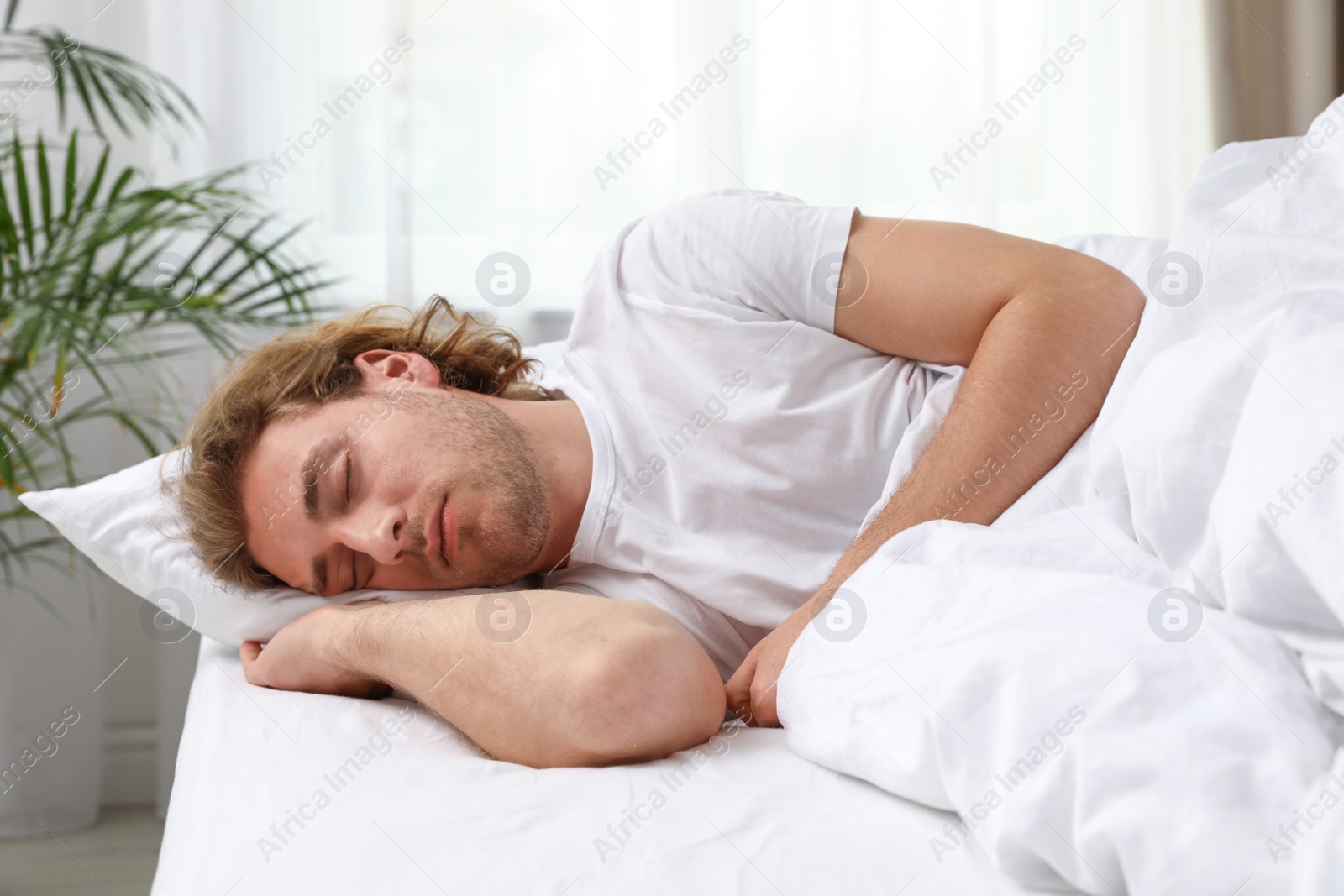 Photo of Handsome young man sleeping on pillow at home. Bedtime