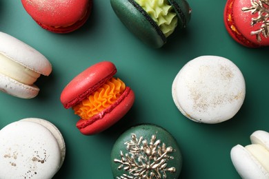 Photo of Beautifully decorated Christmas macarons on green background, flat lay