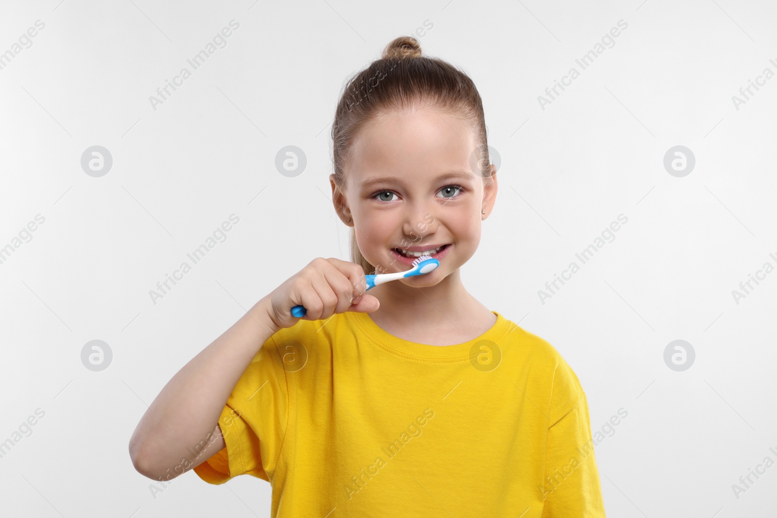 Photo of Happy girl brushing her teeth with toothbrush on white background