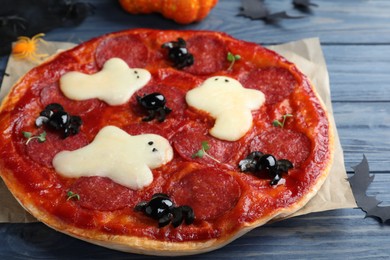 Cute Halloween pizza with ghosts and spiders served on blue wooden table, closeup