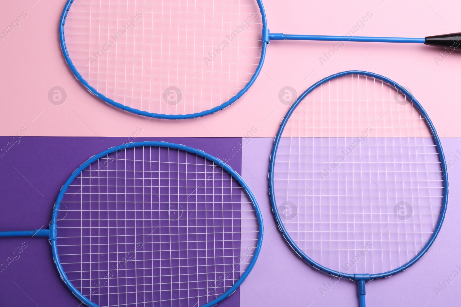 Photo of Badminton rackets on color background, flat lay