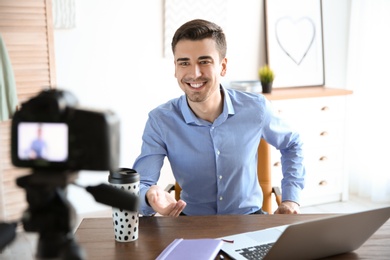 Young blogger recording video at table