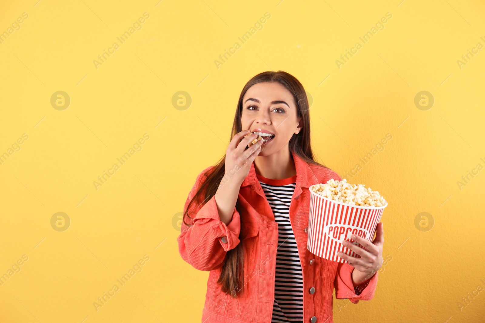 Photo of Young woman with tasty popcorn on color background