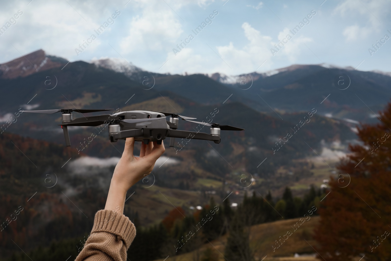 Photo of Woman with modern drone in mountains, closeup. Space for text