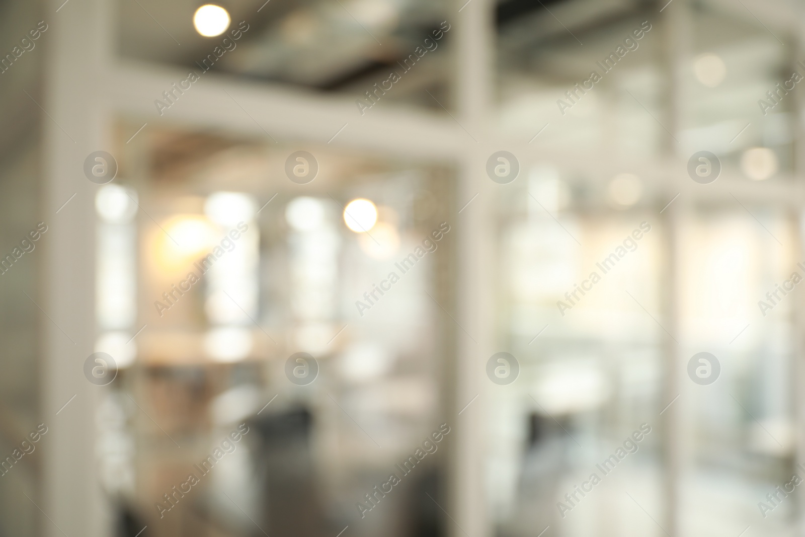 Photo of Blurred view of empty corridor with glass door in company