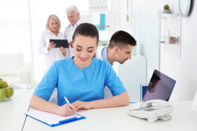 Photo of Young female receptionist working in hospital
