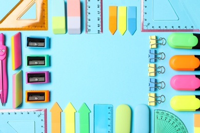 Photo of Frame of different stationery on light blue background, flat lay with space for text. Back to school