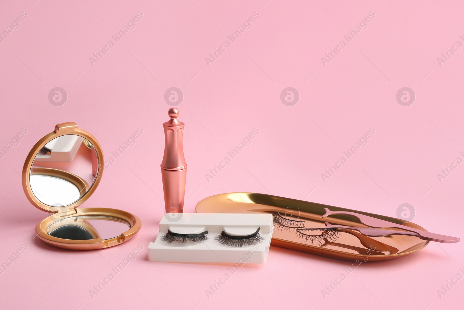 Photo of Magnetic eyelashes and accessories on pink background