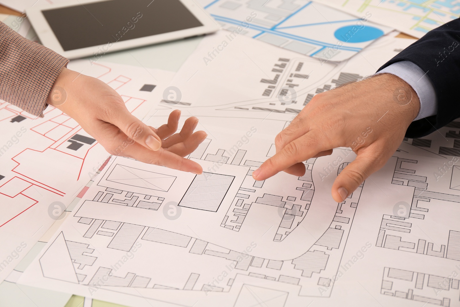 Photo of Professional cartographers working with cadastral map at table, closeup