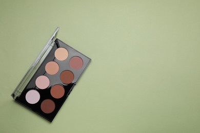 Photo of Colorful contouring palette on pale green background, top view with space for text. Professional cosmetic product