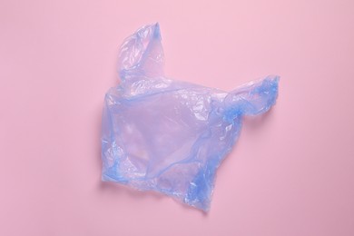 Photo of One plastic bag on pink background, top view