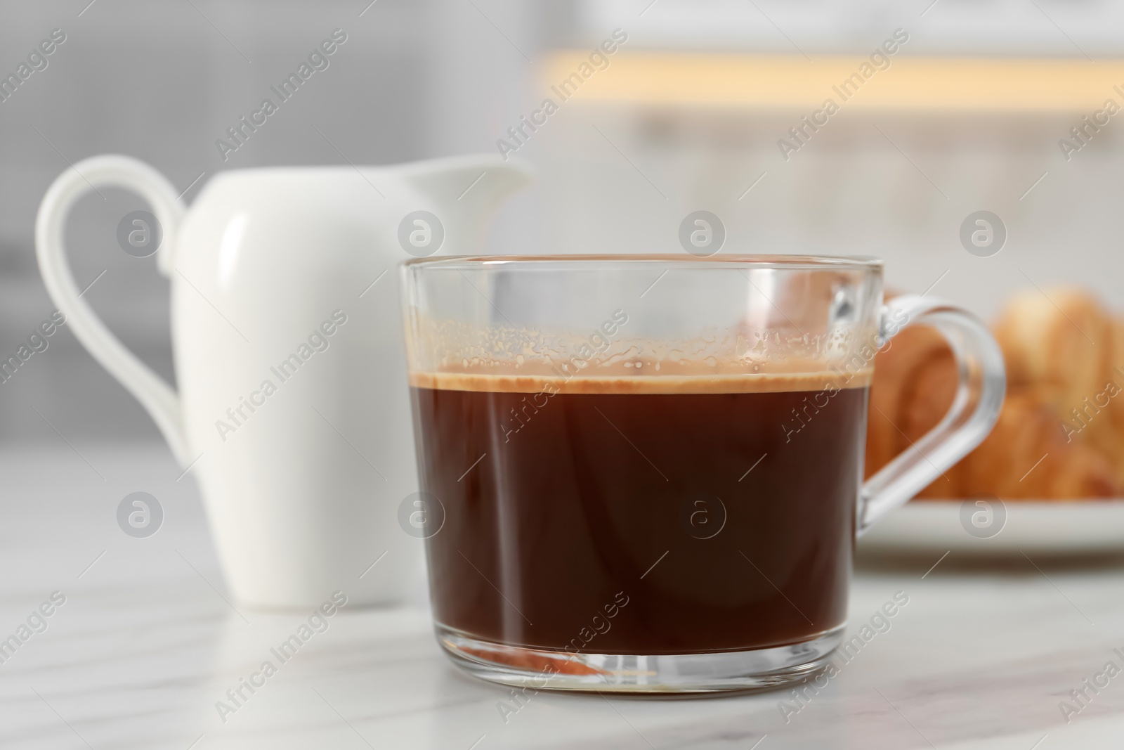 Photo of Aromatic coffee in glass cup on white marble table