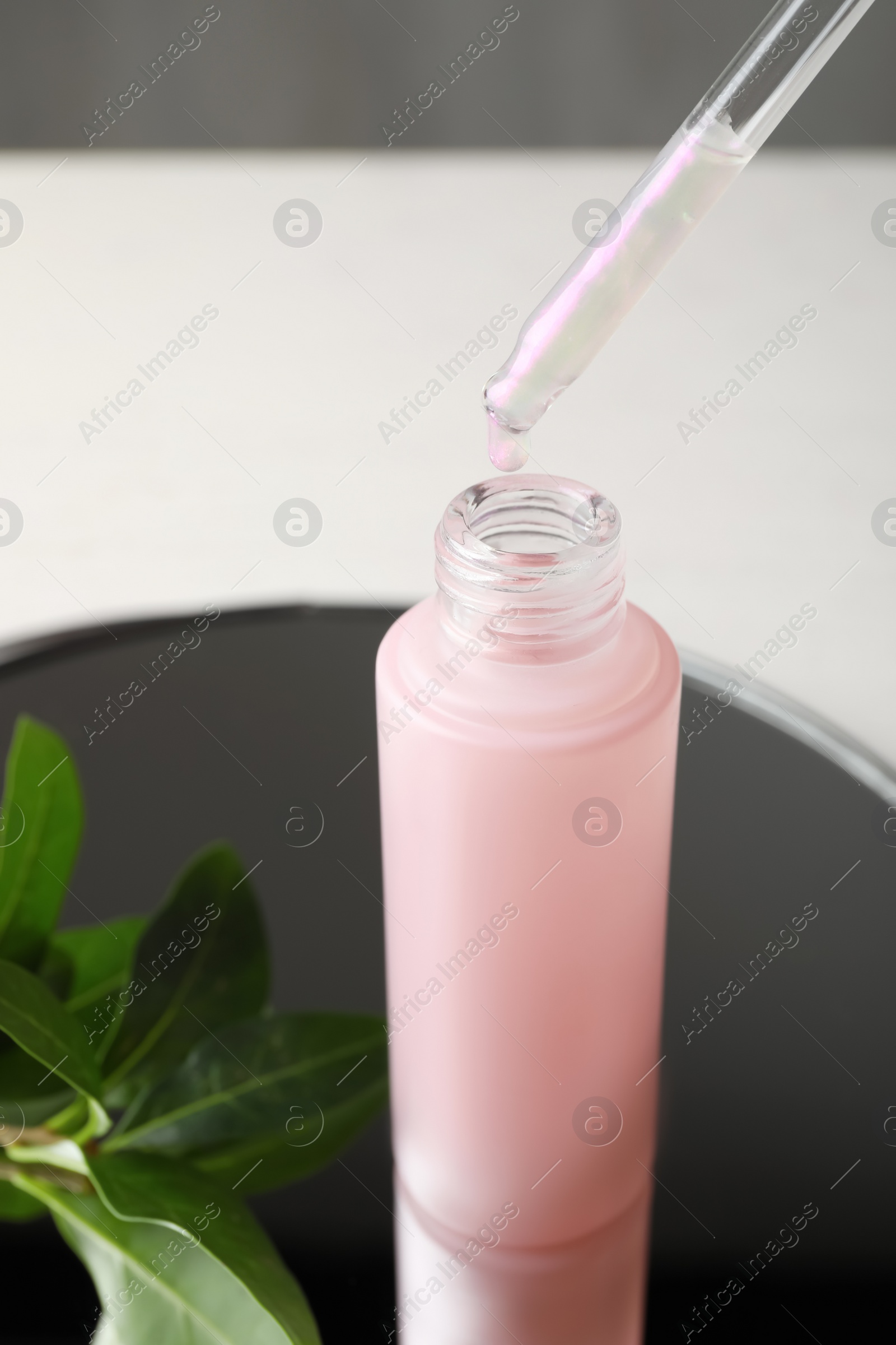 Photo of Dripping of serum into bottle on mirror tray, closeup