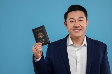 Photo of Immigration. Happy man with passport on light blue background, space for text