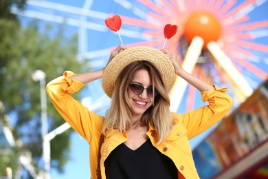 Beautiful woman with candies having fun at amusement park