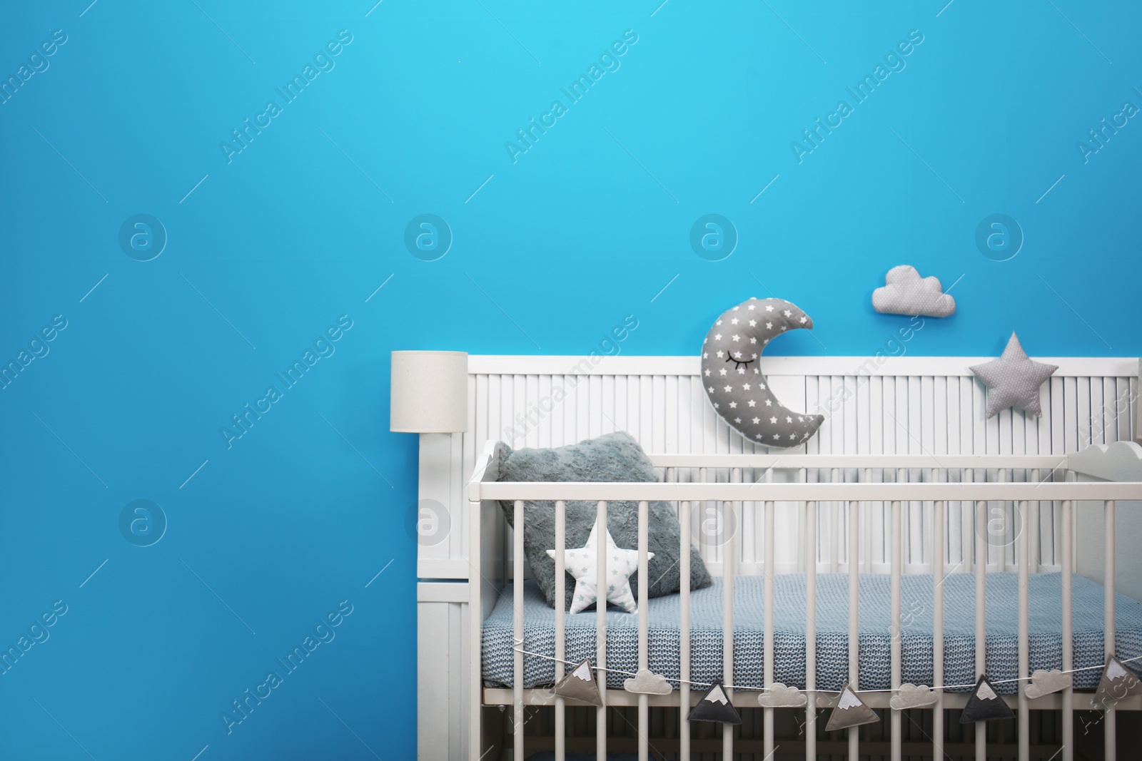 Photo of Baby room interior with crib near color wall