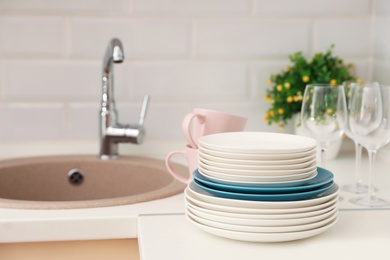 Photo of Clean dishes on counter near kitchen sink indoors