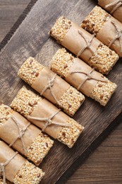 Photo of Tasty sesame seed bars on wooden table, top view