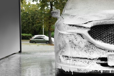 Auto with cleaning foam at car wash