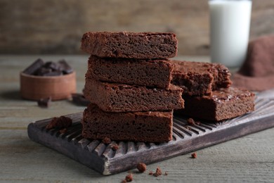 Photo of Delicious chocolate brownies on wooden table. Tasty dessert