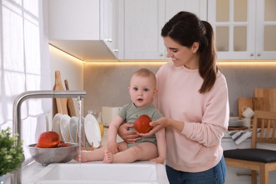 Mother and her cute little baby spending time Woman holding fresh apple