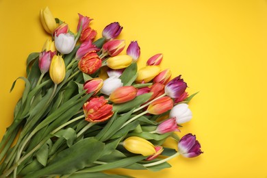 Photo of Beautiful colorful tulip flowers on yellow background, flat lay. Space for text