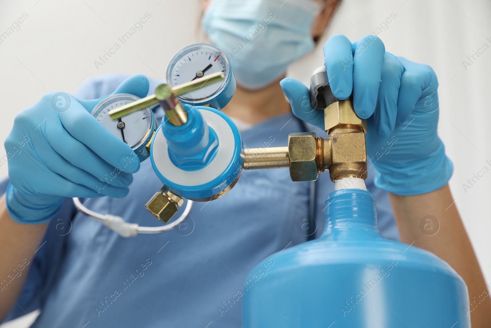 Photo of Medical worker checking oxygen tank in hospital room, closeup