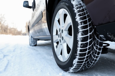 Photo of Car with winter tires on snowy road, closeup view