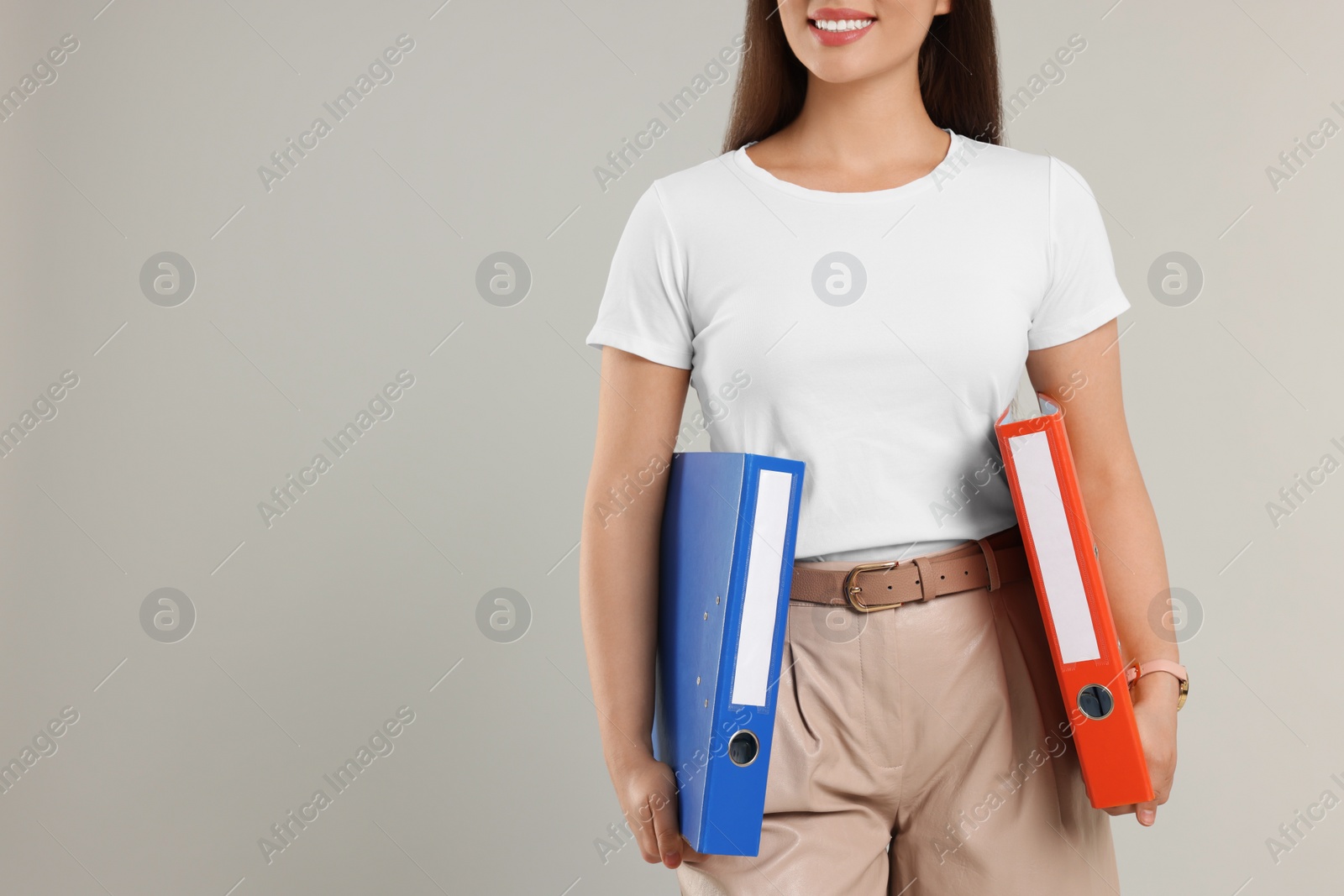 Photo of Woman with folder on light gray background, closeup. Space for text