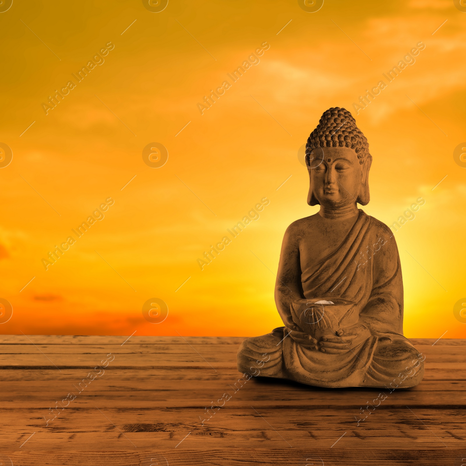 Image of Beautiful stone Buddha sculpture on wooden surface at sunset. Space for text