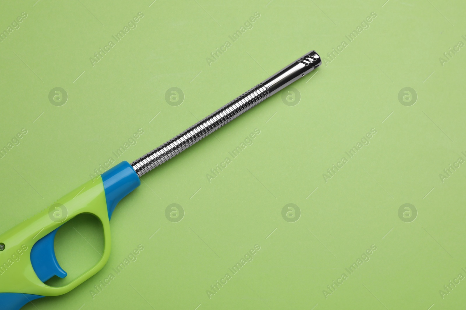 Photo of One gas lighter on green background, top view. Space for text