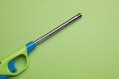 Photo of One gas lighter on green background, top view. Space for text