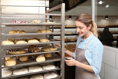 Baker at rack with pastries in workshop