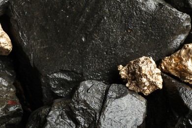 Photo of Shiny gold nuggets on wet stones, above view
