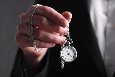 Man holding chain with elegant pocket watch, closeup