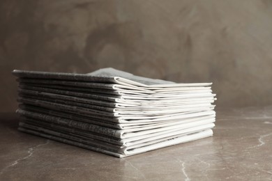 Photo of Stack of newspapers on marble table. Journalist's work