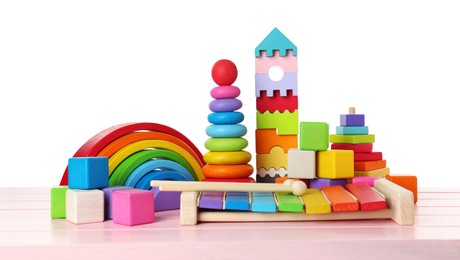 Photo of Different children's toys on pink wooden table against white background