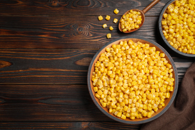 Photo of Delicious canned corn in bowl on wooden table, flat lay. Space for text