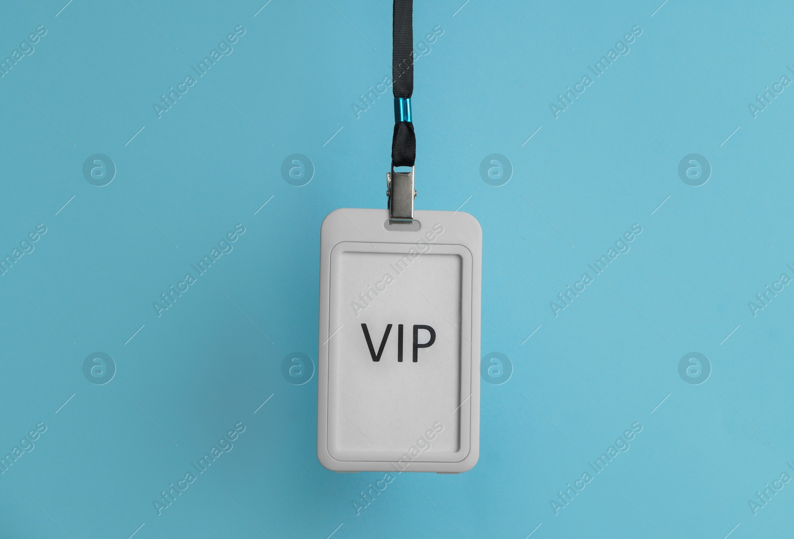 Photo of Plastic vip badge hanging on light blue background