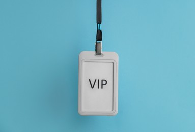 Photo of Plastic vip badge hanging on light blue background