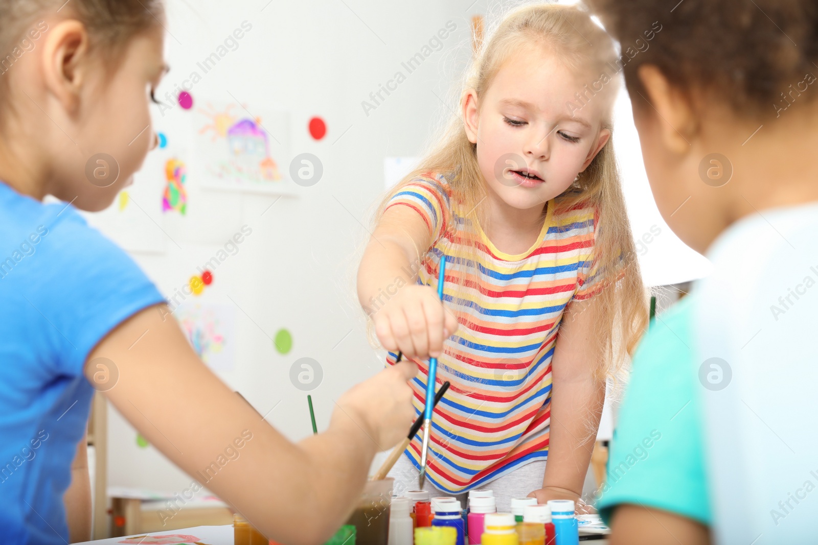 Photo of Cute little children painting at lesson indoors