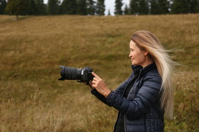 Photo of Professional photographer with camera in nature. Space for text