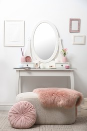 Photo of Dressing table with decor near white wall in room