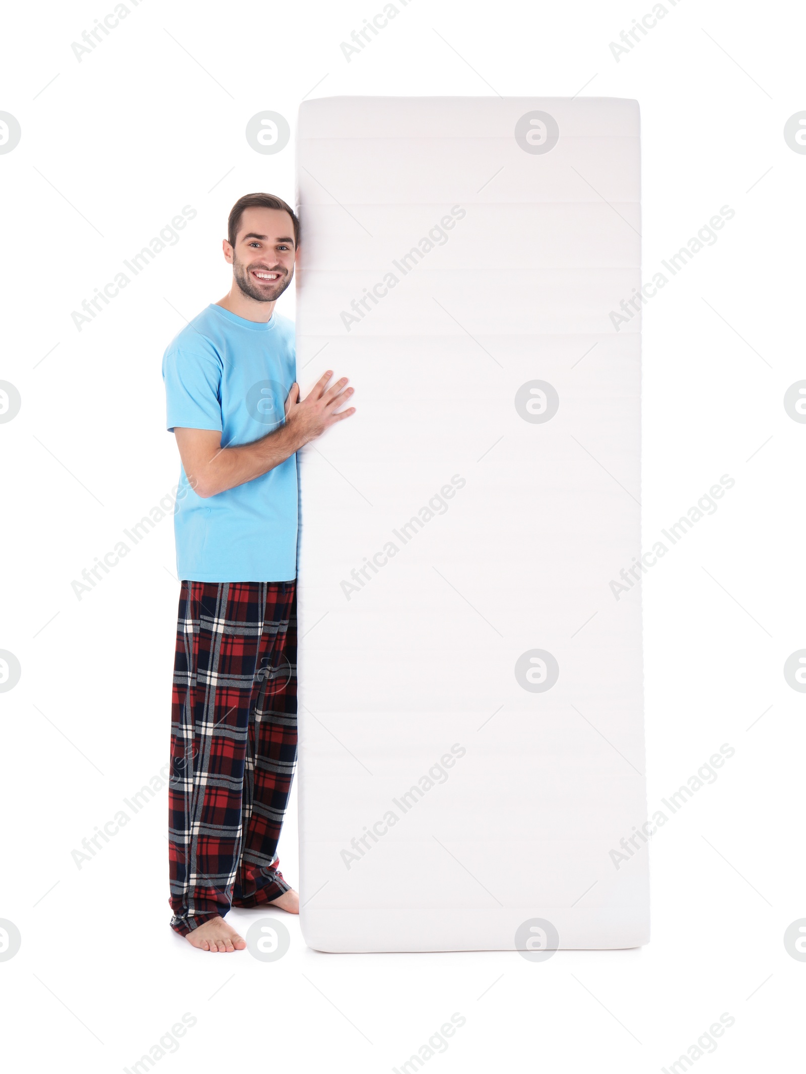 Photo of Young man with comfortable mattress isolated on white