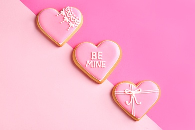 Photo of Decorated heart shaped cookies on color background, top view. Valentine's day treat